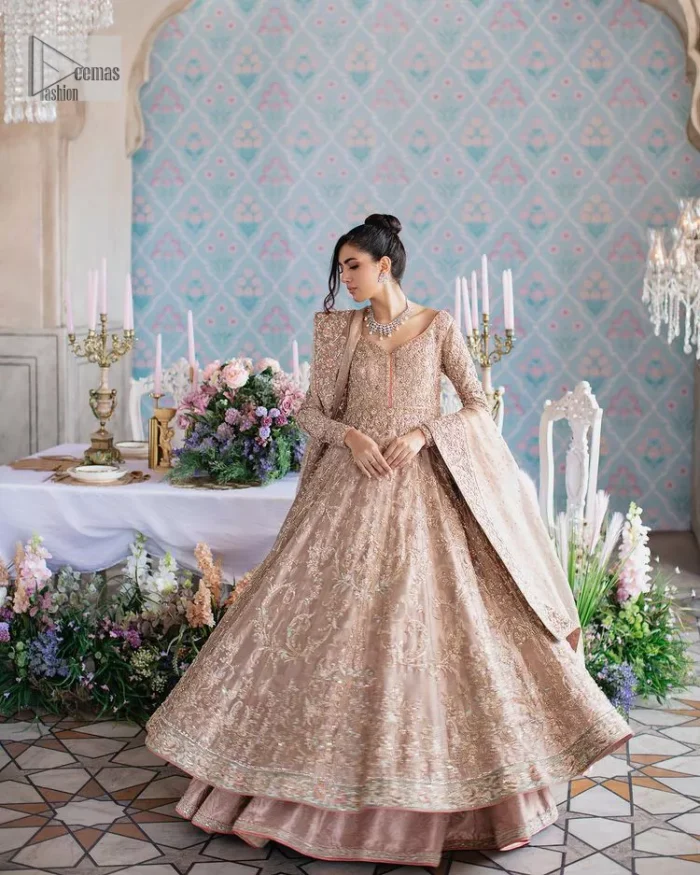 Make your Qabool Hai moment more memorable with this outfit by DeemasFashion. A dreamy statement of this dress proffers a soft pink hue with glamorous silver and golden embroidery.  It is further enhanced with tilla, dabka, kora, Kundan and the real magic of zardozi. V neckline enhances the overall glamour of this masterpiece. Intricate designs and fine details on the sleeves give a perfect finishing look to this maxi. The maxi is layered over a meticulously handcrafted lehnga which is bold enough to stand out in the crowd. Finish this article with a dupatta which is ornamented with four-sided borders and sequins sprayed all over which is a unique piece for your Nikah look. 