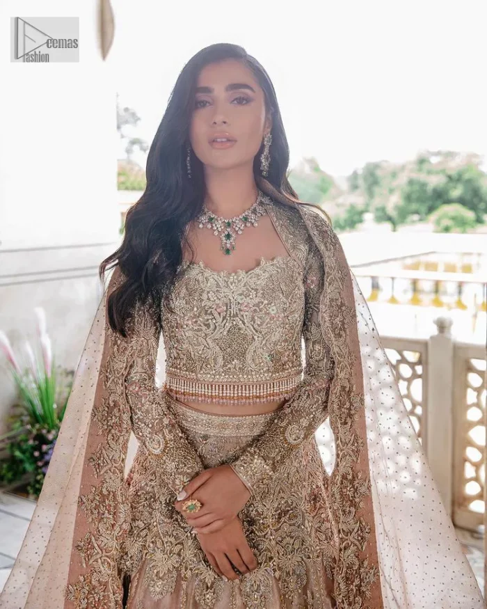 Trendy embroidery on a classic base – A perfect combination for your Nikah! DeemasFashion presents the tea rose article which is laboriously embellished with light golden embroidery which is further enhanced with tilla, dabka, kora, Kundan and beautiful details of Zardozi. The neckline is decorated with handsome embroidery. Further, the full sleeves of the blouse are unique in style and have a classy look and perfect choice for a bride. It is paired with flared lehenga which is heavily ornamented with embroidery to make your day memorable. Complete this article with a dupatta, framed with four-sided borders and sequins spray all over which is giving a charming finishing look to the dress.
