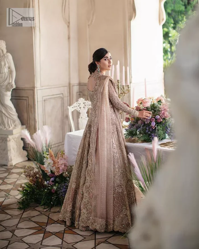 Trendy embroidery on a classic base – A perfect combination for your Nikah! DeemasFashion presents the tea rose article which is laboriously embellished with light golden embroidery which is further enhanced with tilla, dabka, kora, Kundan and beautiful details of Zardozi. The neckline is decorated with handsome embroidery. Further, the full sleeves of the blouse are unique in style and have a classy look and perfect choice for a bride. It is paired with flared lehenga which is heavily ornamented with embroidery to make your day memorable. Complete this article with a dupatta, framed with four-sided borders and sequins spray all over which is giving a charming finishing look to the dress.