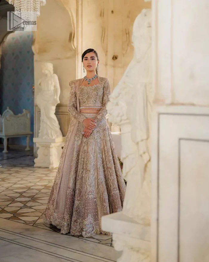 Trendy embroidery on a classic base – A perfect combination for your Nikah! DeemasFashion presents the tea rose article which is laboriously embellished with light golden embroidery which is further enhanced with tilla, dabka, kora, Kundan and beautiful details of Zardozi. The neckline is decorated with handsome embroidery. Further, the full sleeves of the blouse are unique in style and have a classy look and perfect choice for a bride. It is paired with flared lehenga which is heavily ornamented with embroidery to make your day memorable. Complete this article with a dupatta, framed with four-sided borders and sequins spray all over which is giving a charming finishing look to the dress.