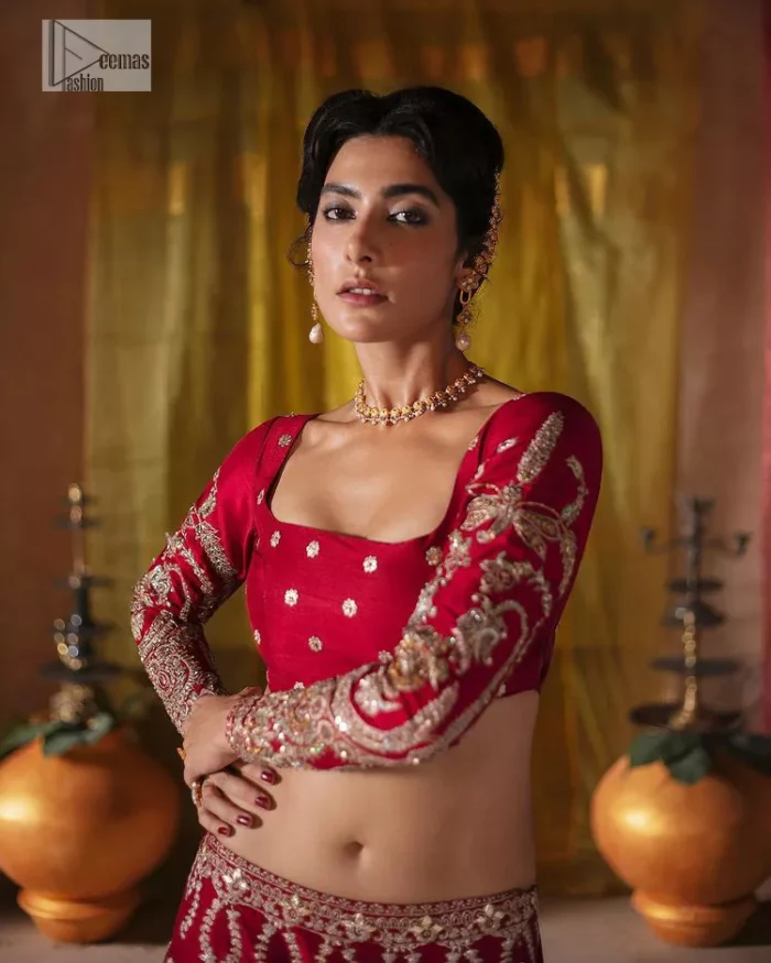 We are Introducing a wine red blouse and lehenga to our wide range of charming bridal dresses. The Pakistani reception Lehenga is an amalgamation of contemporary and traditional art which is decorated with golden embroidery. The embroidery is further enhanced with tilla, dabka, kora, Kundan and detailing of zardozi. It is paired up with a wine red blouse which is adorned with tiny floral motifs. The full sleeves of the blouse are heavily embellished to increase the beauty of the outfit. Further, the square neckline makes this blouse a unique masterpiece. Finish this with a dupatta with a four-sided embellished border and floral motifs all over.