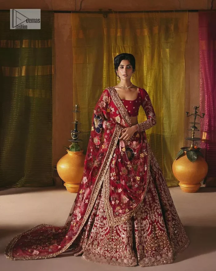 We are Introducing a wine red blouse and lehenga to our wide range of charming bridal dresses. The Pakistani reception Lehenga is an amalgamation of contemporary and traditional art which is decorated with golden embroidery. The embroidery is further enhanced with tilla, dabka, kora, Kundan and detailing of zardozi. It is paired up with a wine red blouse which is adorned with tiny floral motifs. The full sleeves of the blouse are heavily embellished to increase the beauty of the outfit. Further, the square neckline makes this blouse a unique masterpiece. Finish this with a dupatta with a four-sided embellished border and floral motifs all over.