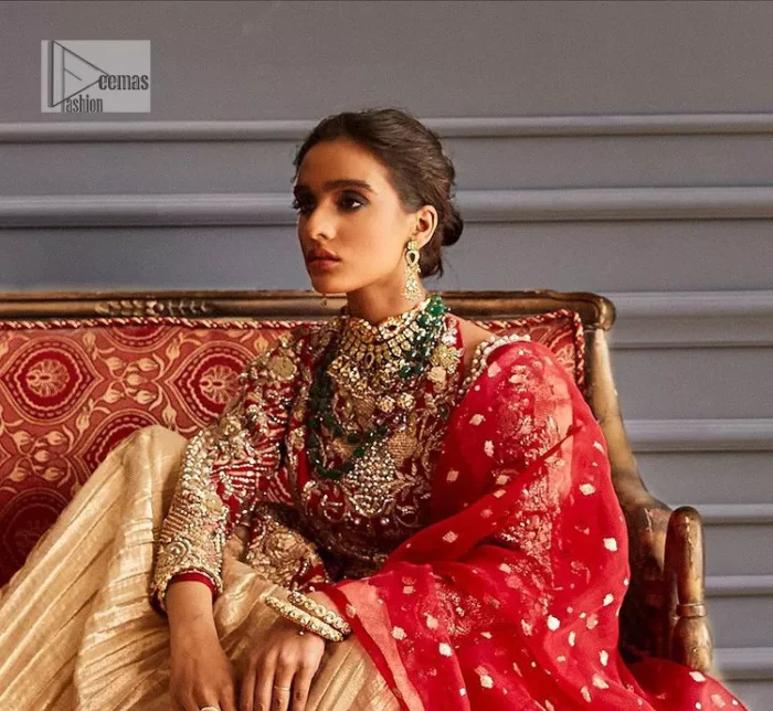 The magic of luxurious romantic outfits at your reception, giving out love and letting it come in. The Beautiful bright red short frock is adorned with classy golden embroidery and will look breathtaking on the traditional bride. The boat shape neckline makes this frock a glamorous choice to pair with the classy golden crushed lehenga. In addition to this, the following frock is enhanced with tilla, dabka, kora, Kundan and the real magic of zardozi. Crushed Lehenga paired with the Embellished frock enhances the overall Royal look of the outfit. The perfect stitching and crushed style make this Lehenga your first-ever priority. Complete this article with a scalloped dupatta that is embellished with four-sided borders and sequins sprayed all over.