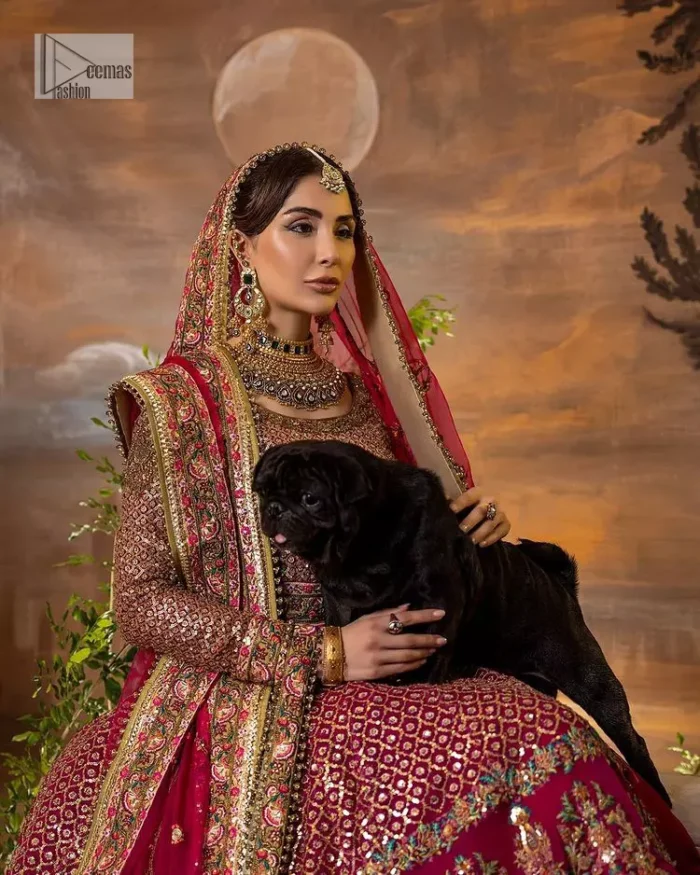 Experience the true essence of reception wear in alluring attires from DeemasFashion. The host pink pishwas is decorated with multiple colour embroidery which is handsomely enhanced with tilla, dabka, kora, Kundan and the real magic of Zardozi to make this masterpiece unique and charming. The finishing of boat shape neckline enhances the beauty of the attire. Furthermore, the full sleeves of the pishwas are a perfectly charming choice to pair with a Pishwas. It is coordinated with a jamawar lehenga whose border is adorned with beautiful embroidery. Complete this article with a dupatta framed with four-sided embellished borders and sequins sprayed all over.