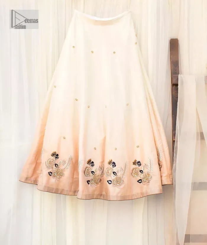 The fusion of this softest canvas decorated with vibrant contrasts is all you need to stun at any party! The embellished ivory article is the season’s most irresistible trend, the new-age lehenga blouse. The impeccably tailored choli has delicate multiple colour embroidery which intensifies with tilla, dabka, kora, Kundan and magic of Zardozi. The round neckline of the blouse is a beautifully crafted ensemble when combined with sleeveless style. The following blouse is paired with a double-tone can-can lehenga which is ornamented with embroidery on the border making it a perfect choice to pair with this masterpiece.
