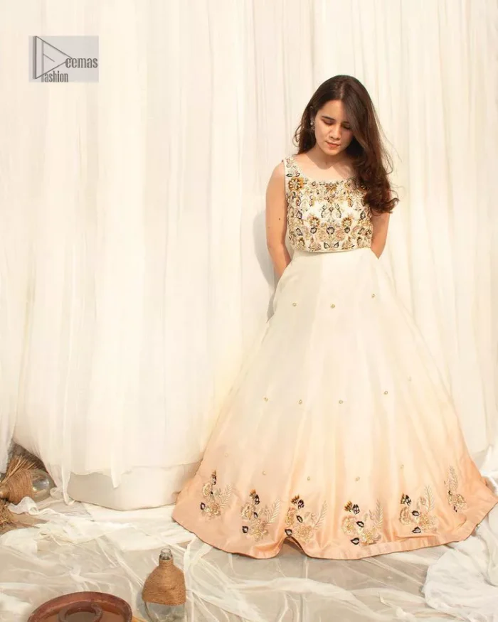 The fusion of this softest canvas decorated with vibrant contrasts is all you need to stun at any party! The embellished ivory article is the season’s most irresistible trend, the new-age lehenga blouse. The impeccably tailored choli has delicate multiple colour embroidery which intensifies with tilla, dabka, kora, Kundan and magic of Zardozi. The round neckline of the blouse is a beautifully crafted ensemble when combined with sleeveless style. The following blouse is paired with a double-tone can-can lehenga which is ornamented with embroidery on the border making it a perfect choice to pair with this masterpiece.