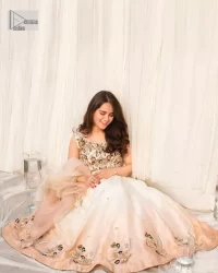 The fusion of this softest canvas decorated with vibrant contrasts is all you need to stun at any party! The embellished ivory article is the season’s most irresistible trend, the new-age lehenga blouse. The impeccably tailored choli has delicate multiple colour embroidery which intensifies with tilla, dabka, kora, Kundan and magic of Zardozi. The round neckline of the blouse is a beautifully crafted ensemble when combined with sleeveless style. The following blouse is paired with a double-tone can-can lehenga which is ornamented with embroidery on the border making it a perfect choice to pair with this masterpiece.