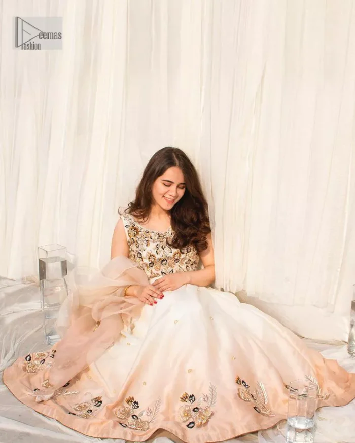 The fusion of this softest canvas decorated with vibrant contrasts is all you need to stun at any party! The embellished ivory article is the season’s most irresistible trend, the new-age lehenga blouse. The impeccably tailored choli has delicate multiple colour embroidery which intensifies with tilla, dabka, kora, Kundan and magic of Zardozi. The round neckline of the blouse is a beautifully crafted ensemble when combined with sleeveless style. The following blouse is paired with a double-tone can-can lehenga which is ornamented with embroidery on the border making it a perfect choice to pair with this masterpiece.