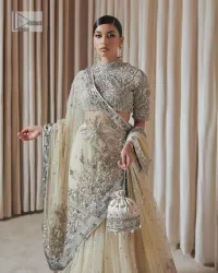 The perfect balance of simplicity and flamboyance is the essence of the beautiful Walima outfit. The blouse in off-white colour is beautifully embellished with Dabka, Tilla, Zardozi and delicate yet intricate crystal work. The beautiful classy artistic half sleeves design maintains the charm of this blouse. The beautiful outfit is epitome of beauty by its high neckline . It is paired up with flared lehenga in the same colour, framed with a sequins sprayed all over. Further, beautiful silver embroidery on the four sided border of the dupatta will enhance the overall magnificent look.