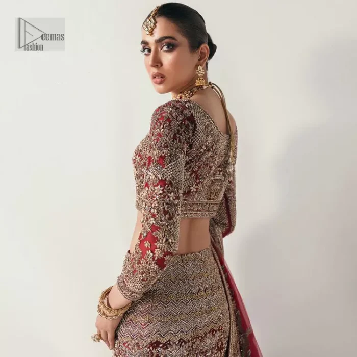 Walk with style at your reception and let the people follow! A stunning wine red blouse is embellished with intricate detailing and finished with light golden embroidery. It is further enhanced with the glorious amalgamation of zardozi, dabka, tilla, and elaborate stonework. Featuring a delicately embellished round neckline highlighted with zardozi detailing. The three-quarter sleeves of the following blouse give this outfit a unique look.  It is paired with a heavily embellished fish-cut lehenga with floral patterns that helps to sustain a traditional craft. Its dupatta is made from wine red net. Enveloping the sequin sprayed dupatta framed with a four-sided border that added divine pleasure to the entire article.