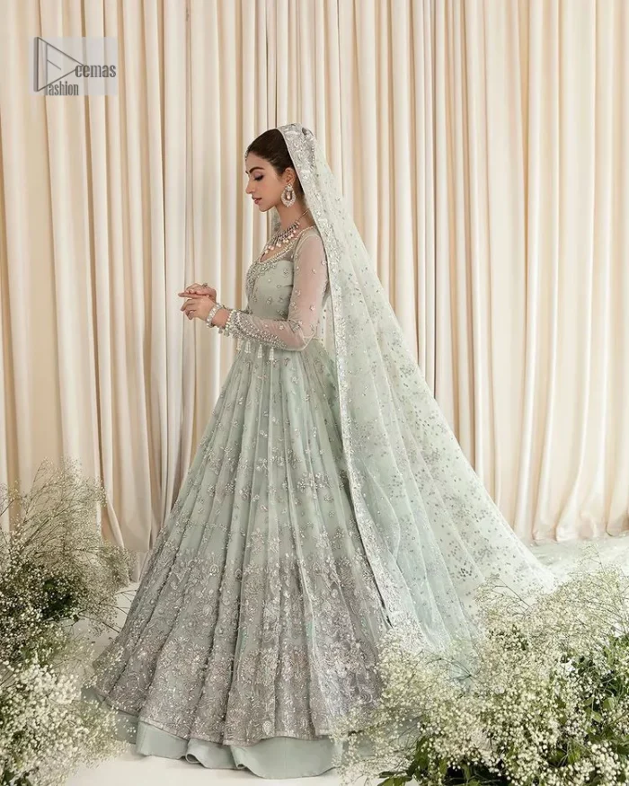 Exquisitely designed ensembles with delicate embroideries & traditional embellishments for nikah outfit statements. This beautiful maxi that comes in aqua blue colour is beautifully embellished with crystals and zardozi work. Beads, motifs,tilla, dabka, sequins, and shimmering adornments enhance the overall charm of this alluring maxi. Perfect stitching and intricate details give a royal appearance to the Bride. The bodice has a delicate and feminine V shape neckline with embellished full sleeves. Paired with lehnga and an alluring dupatta with a heavy spray of sparkling sequins and a detailed head embellished border to make your day super charming.