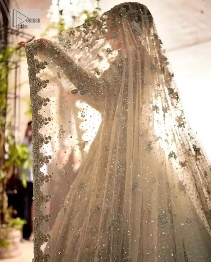 The magic reflects in every piece of this nikah wear. DeemasFashion presents a stunning outfit in an aqua-blue colour. A heavenly designed aqua blue maxi on an organza base serves as a canvas for spellbinding embellishments of gold, tilla, dabka, kora, Kundan and sequins. It is highlighted with silver embroidery to gain the spotlight of the show. The jewel neckline and full sleeves are rendered with beautiful floral patterns and embroidered borders. It is organized with a lehenga in the same colour, adorned with beautiful embroidery giving the perfect final touch. Complete this outfit with a dupatta in the same colour. This dupatta is adorned with floral motifs and silverwork. The embellished borders of this delicate net dupatta make this article your foremost priority.