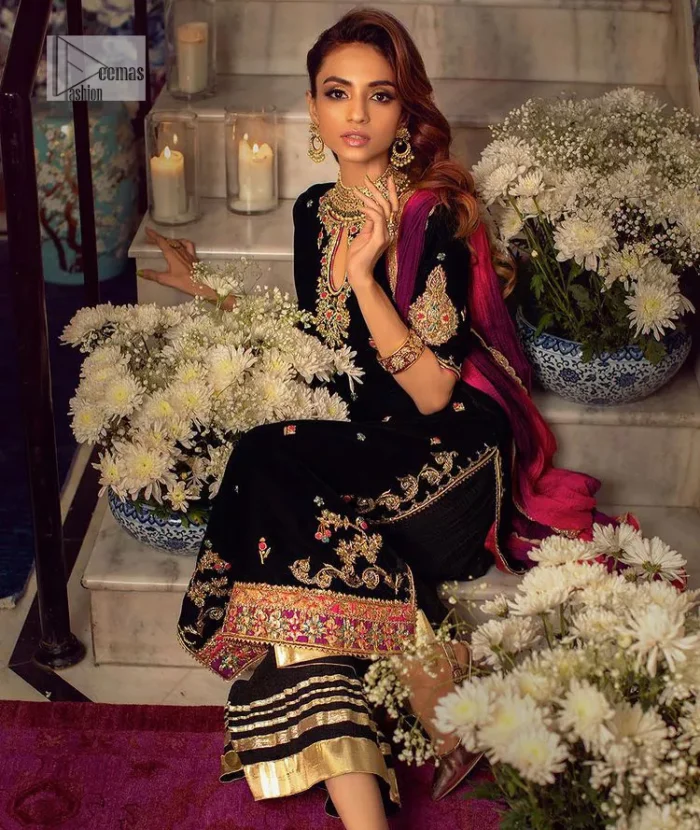 This outfit glam up in our detailed embroidered fabrics made to make you shine for every occasion. The black long shirt in premium quality velvet is beautifully decorated with multiple colour embroidery which is further enhanced with tilla, dabka, kora, Kundan and the real magic of Zardozi. The following shirt has an embellished neckline to meet the trending grace. Further, the half sleeves are adorned with floral motifs. It is coordinated with sharara in the same colour to balance the overall royal look of this party wear. Complete this article with a dupatta in the double shade that is a beautiful piece for a bridesmaid who has a unique taste.
