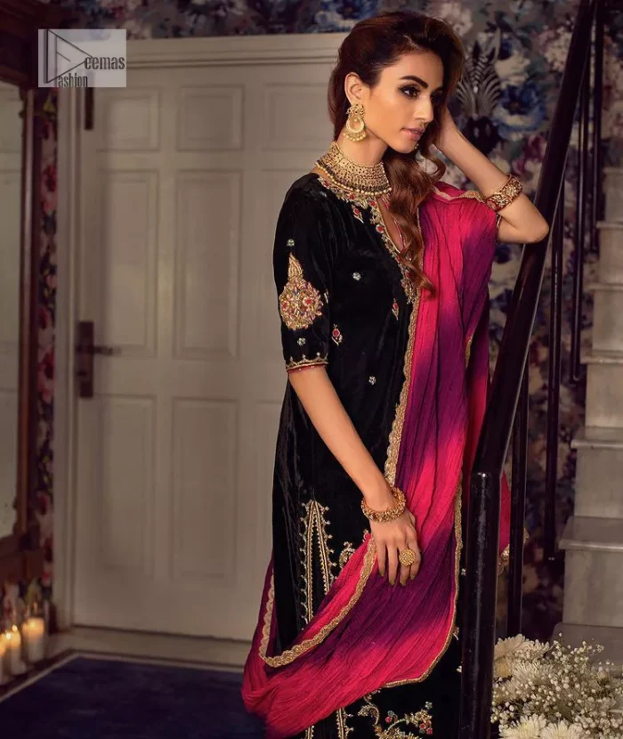 This outfit glam up in our detailed embroidered fabrics made to make you shine for every occasion. The black long shirt in premium quality velvet is beautifully decorated with multiple colour embroidery which is further enhanced with tilla, dabka, kora, Kundan and the real magic of Zardozi. The following shirt has an embellished neckline to meet the trending grace. Further, the half sleeves are adorned with floral motifs. It is coordinated with sharara in the same colour to balance the overall royal look of this party wear. Complete this article with a dupatta in the double shade that is a beautiful piece for a bridesmaid who has a unique taste.