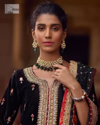 This outfit glam up in our detailed embroidered fabrics made to make you shine for every occasion. The black long shirt in premium quality velvet is beautifully decorated with multiple colour embroidery which is further enhanced with tilla, dabka, kora, Kundan and the real magic of Zardozi. The following shirt has an embellished neckline to meet the trending grace. Further, the half sleeves are adorned with floral motifs. It is coordinated with sharara in the same colour to balance the overall royal look of this party wear. Complete this article with a dupatta in the double shade that is a beautiful piece for a bridesmaid who has a unique taste.