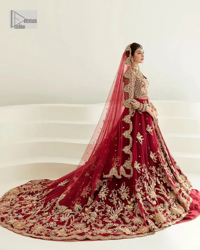 Be a dreamy vision in this reception wear. The beautiful pishwas in the bright red shade is embellished with intricate designs and fine details. It is enhanced with hand-crafted golden embroidery with details of tilla, dabka, kora, Kundan and magic of Zardozi. The round neckline and three-quarter sleeves feature a heavily crafted geometric pattern enhanced by cutwork detailing. The following front open scalloped pishwas is organized with a back train lehenga whose border is beautifully decorated with embroidery making it an epitome of beauty and grace. Furthermore, The embellished borders of the red scalloped dupatta give a perfectly glamorous look to the beautiful overall outfit. It is also intensified with sequins spray.