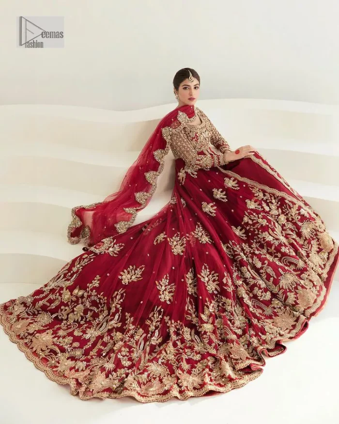 Be a dreamy vision in this reception wear. The beautiful pishwas in the bright red shade is embellished with intricate designs and fine details. It is enhanced with hand-crafted golden embroidery with details of tilla, dabka, kora, Kundan and magic of Zardozi. The round neckline and three-quarter sleeves feature a heavily crafted geometric pattern enhanced by cutwork detailing. The following front open scalloped pishwas is organized with a back train lehenga whose border is beautifully decorated with embroidery making it an epitome of beauty and grace. Furthermore, The embellished borders of the red scalloped dupatta give a perfectly glamorous look to the beautiful overall outfit. It is also intensified with sequins spray.