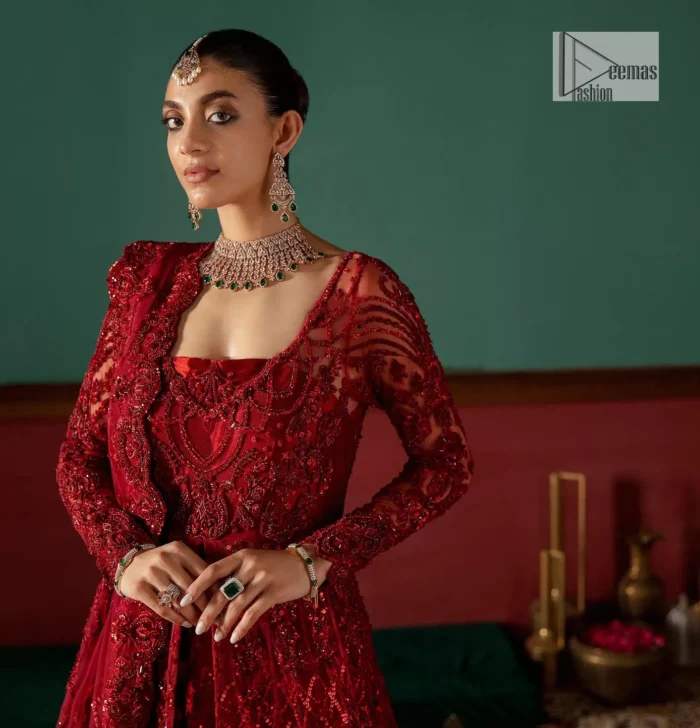 Deep red is just associated with love and romance! For a more lovely and romantic look on your big day just buy this reception wear. The deep red maxi is heavily adorned with intricate hand-worked of tilla, dabka, kora, Kundan and Zardozi in the shade of red which is sure to make you look glamorous on your big day. The square neckline merges rich traditions with modern style. Further, the full sleeves of the maxi also add more charms. It is organized with a back train lehenga which is also embellished and highlighted with floral motifs. Complete this super romantic look with a dupatta which is encrusted with four-sided embellished borders and floral motifs sprinkled all over. 