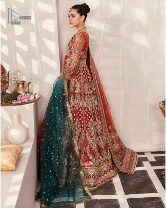This deep rust outfit with a floral pattern has you covered for your big day. This deep rust angrakha is hand rendered in shades of multiple colours. The angrakha is decorated with gota, nakshi, dabka, and tilla in contrasting colours and is attached to hand-embellished panels. Further, the V shape neckline makes this masterpiece unique and priceless. The full sleeves of the following angrakha are a delightful way to add beauty to this mehndi wear. It is paired with a lehenga in the same colour having embroidered borders. Complete this traditional outfit with a dupatta in the green colour which is adorned with a four-sided Kiran and sequins sprayed all over.