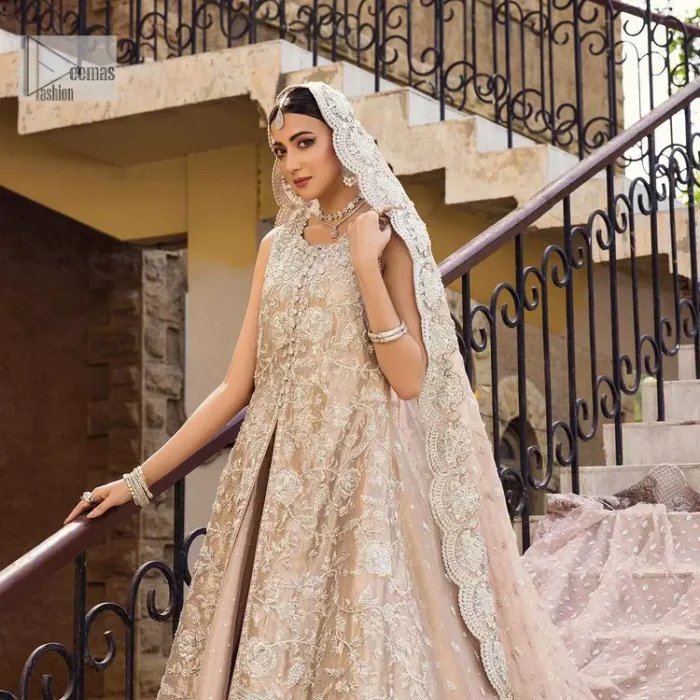 The subtle colour palette, delicate embroidery and eye-catching details. All in all a true style statement! Presenting this fawn maxi which is a luxuriously encrusted masterpiece is laden with tilla, dabka kora, stones,  and delicate Resham. The following front open scalloped maxi is adorned with silver embroidery to make your Nikah day remarkable. The embellished neckline along with the sleeveless style makes you a pretty and unique bride ever. Paired up this article with a sharara whose border is adorned with embroidery. Finish this outfit with a dupatta, framed with four-sided borders and sequins sprayed all over for attractiveness and marvellous details.