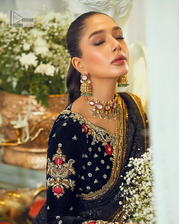 Black, is a reminder to love yourself. The navy blue blouse is augmented with elusive dabka and remarkable naqshi to highlight the grace and is further enhanced with tilla, dabka, koran and Kundan.  The V shape neckline of the following blouse is beautifully decorated with multiple colour embroidery. In addition to this, the heavy floral motifs also adorned the full sleeves to add more charm and beauty to this party wear. It is paired with a black saree to style you according to your choice. Complex work on the borders and the pallu makes it look even more gorgeous. This is a beautiful piece for a bridesmaid who has traditional taste.