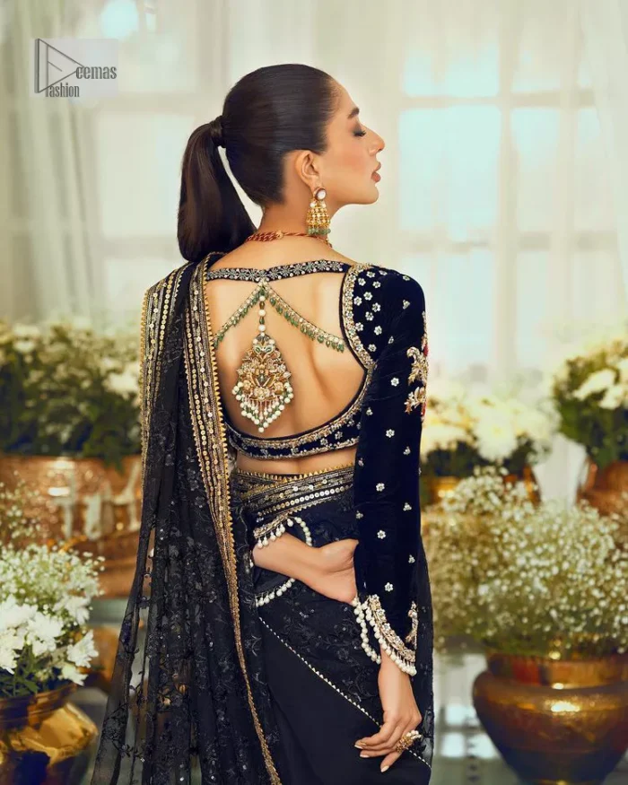 Black, is a reminder to love yourself. The navy blue blouse is augmented with elusive dabka and remarkable naqshi to highlight the grace and is further enhanced with tilla, dabka, koran and Kundan.  The V shape neckline of the following blouse is beautifully decorated with multiple colour embroidery. In addition to this, the heavy floral motifs also adorned the full sleeves to add more charm and beauty to this party wear. It is paired with a black saree to style you according to your choice. Complex work on the borders and the pallu makes it look even more gorgeous. This is a beautiful piece for a bridesmaid who has traditional taste.