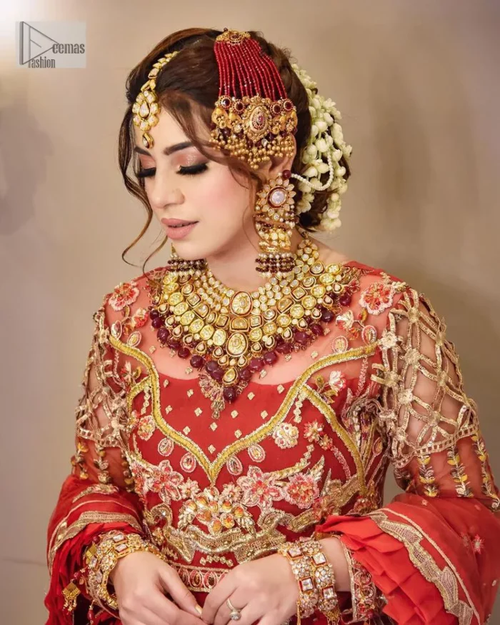The deep orange colour is the perfect feminine and delicate shade with its meticulously crafted untruth. The stunning maxi is ornamented with tilla, dabka, kora, Kundan, Zardozi and crystals. Embroidery is done in the shade of gold.  The illusion neckline of the maxi just steals everyone's heart. Further, the full sleeves of the maxi are also decorated with geometric patterns. The frill of the following maxi gives a perfectly glamorous look to the whole reception wear. It is paired up with a dupatta which is adorned with floral motifs all over.