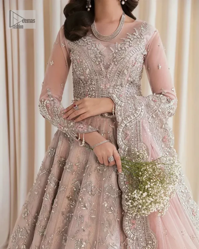 Rose Pink, is the colour of confidence on your big day. The blouse in the rose pink shade is embellished with intricate designs, silverwork, and fine details. The V shape neckline and full sleeves look perfect with the lehenga. Beautiful details of crystals, tilla, dabka, kora, stones, and dabka give a perfect finishing look to the following blouse. It is organized with a lehenga which is heavily adorned with silver embroidery to add more charm and beauty to the outfit. Complete this outfit with a dupatta framed with four-sided borders that gives an elegant look to the gorgeous bride.