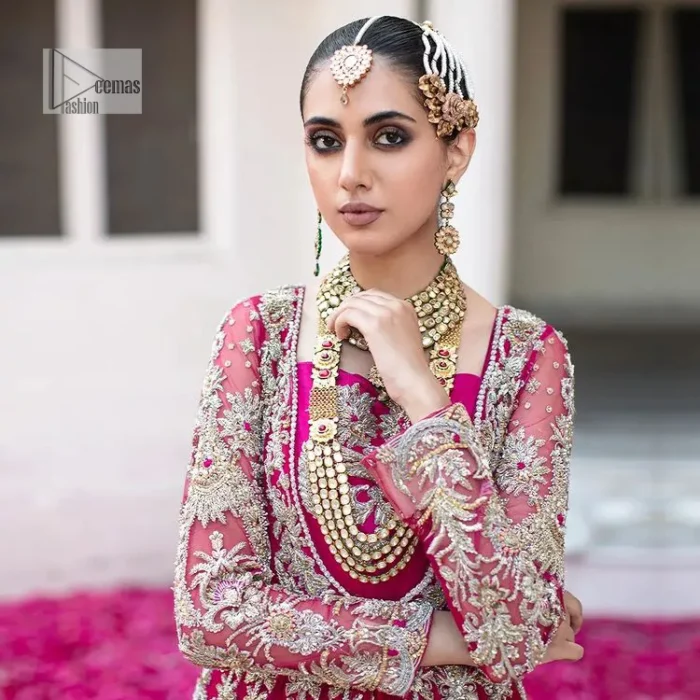 Be a dream vision in this floral shocking pink article. The shocking pink maxi is a breathtaking masterpiece that wins everyone's hearts at the very first glance. The stunning details of silver embroidery which includes tilla, dabka, kora, Kundan and zardozi give a royal touch to this scalloped maxi. The front open style and sweetheart neckline come together to make this outfit lovely and charming. The full sleeves give a glamorous touch to this perfectly maxi. It is paired with Lehenga to create a lavish look. The Lehenga has a huge flare and is also embellished with beautiful embroidery. Complete this walima article with a grey dupatta in a scalloped design which is adorned with a four-sided heavy embellishment. 