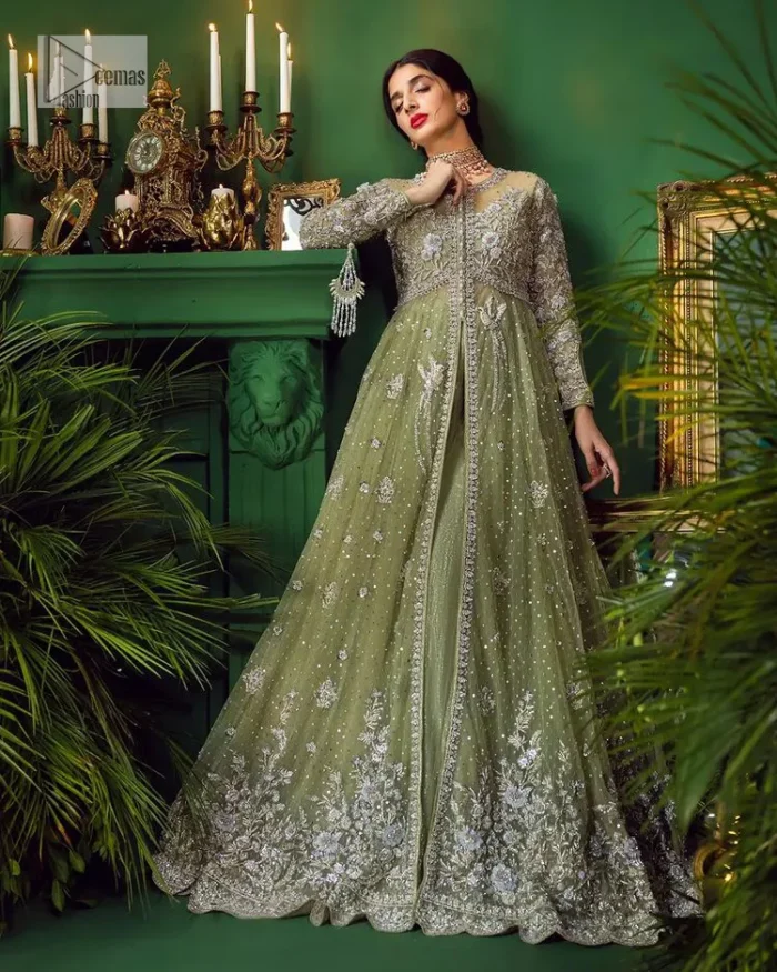 Experience the joy of a wedding in dreamy ensembles. Bringing old-world charm into your festive ensembles, it is a front open scalloped maxi intricately embellished with fine silver embroidery, crystals, tilla, dabka, kora and sequin. The full sleeves of the maxi make it an expression of timeless elegance. In addition to this, the V shape neckline makes this masterpiece unique and priceless. Paired with a long border embellished scalloped dupatta it all comes together to create a luxuriously chic look. The dupatta is also embellished with tiny floral motifs and sequins spray. Complete this party wear with a simple lehenga in the same colour to balance the overall look of the outfit.