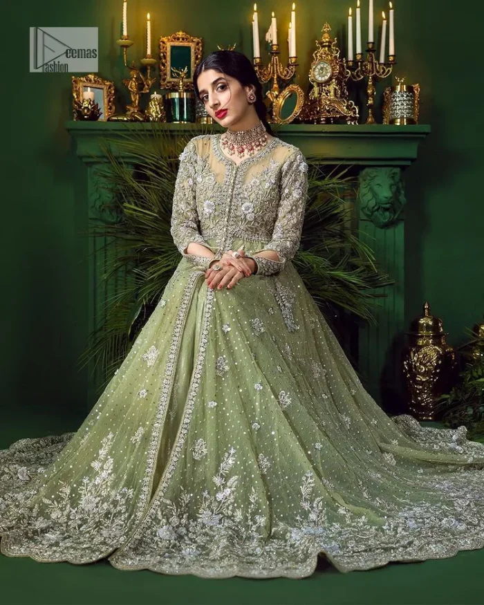 Experience the joy of a wedding in dreamy ensembles. Bringing old-world charm into your festive ensembles, it is a front open scalloped maxi intricately embellished with fine silver embroidery, crystals, tilla, dabka, kora and sequin. The full sleeves of the maxi make it an expression of timeless elegance. In addition to this, the V shape neckline makes this masterpiece unique and priceless. Paired with a long border embellished scalloped dupatta it all comes together to create a luxuriously chic look. The dupatta is also embellished with tiny floral motifs and sequins spray. Complete this party wear with a simple lehenga in the same colour to balance the overall look of the outfit.