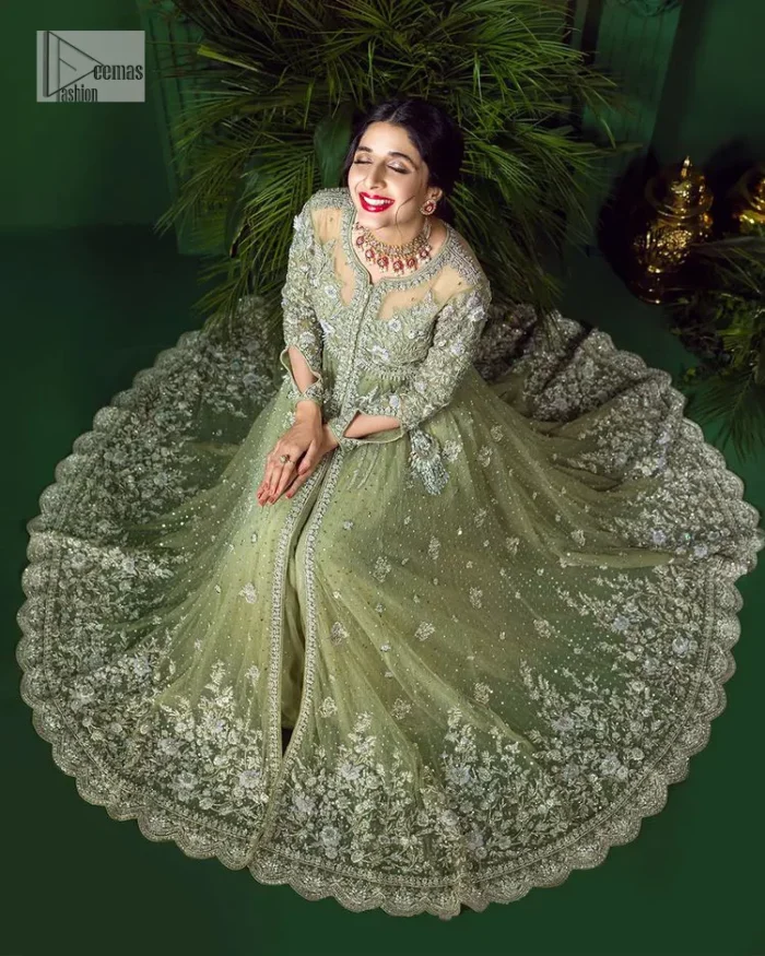 Experience the joy of a wedding in dreamy ensembles. Bringing old-world charm into your festive ensembles, it is a front open scalloped maxi intricately embellished with fine silver embroidery, crystals, tilla, dabka, kora and sequin. The full sleeves of the maxi make it an expression of timeless elegance. In addition to this, the V shape neckline makes this masterpiece unique and priceless. Paired with a long border embellished scalloped dupatta it all comes together to create a luxuriously chic look. The dupatta is also embellished with tiny floral motifs and sequins spray. Complete this party wear with a simple lehenga in the same colour to balance the overall look of the outfit.