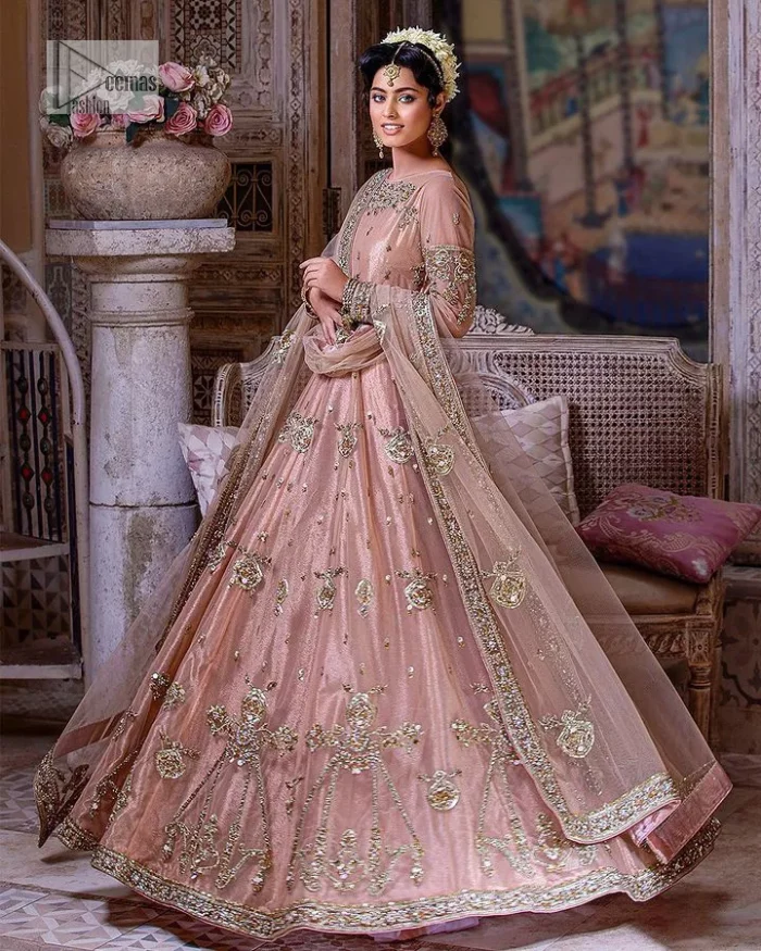 Wrap yourself in stunning style on your Big day. This tea-pink maxi dupatta is a stunning attire to wear at the wedding. This breathtaking nikah wear is gracefully adorned with hand-crafted embellishments and lavish golden work creating a magnificent masterpiece to give you your desired appearance. Intricate designs, floral details, naqshi, kora, Kundan, tilla and dabka o maxi enhance the overall charm of this beautiful outfit. The full sleeves of the maxi are highlighted with golden embroidery. Further, the boat shape neckline makes this outfit an epitome of beauty. It is systemized with a dupatta in the same colour adorned with four-sided borders and floral motifs all over.