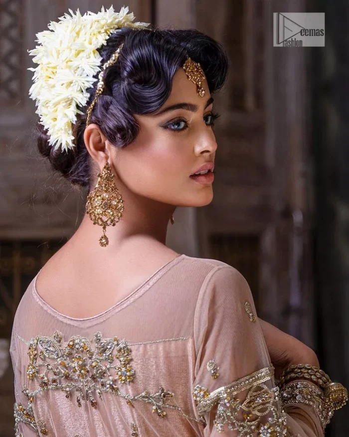 Wrap yourself in stunning style on your Big day. This tea-pink maxi dupatta is a stunning attire to wear at the wedding. This breathtaking nikah wear is gracefully adorned with hand-crafted embellishments and lavish golden work creating a magnificent masterpiece to give you your desired appearance. Intricate designs, floral details, naqshi, kora, Kundan, tilla and dabka o maxi enhance the overall charm of this beautiful outfit. The full sleeves of the maxi are highlighted with golden embroidery. Further, the boat shape neckline makes this outfit an epitome of beauty. It is systemized with a dupatta in the same colour adorned with four-sided borders and floral motifs all over.