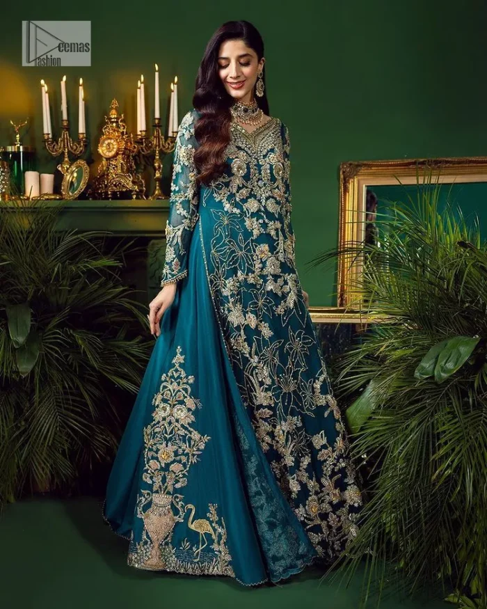 Let the outfit speak for itself! DeemasFashion presents this party wear in teal blue colour.  Be a centre of attraction by donning this beautiful teal blue long shirt embellished with tilla, dabka, kora, Kundan and sequins work which is further intensified with silver and golden embroidery. The shirt is emphasized with a sweetheart neckline and full sleeves to make your day super romantic. It is organized with a lehenga which is embellished with embroidered floral motifs to explain the love of the bride. To finish this article, the last but not least piece comes that is the dupatta which is adorned with four-sided heavily embellished borders and sequins spray that accentuates the whole look.