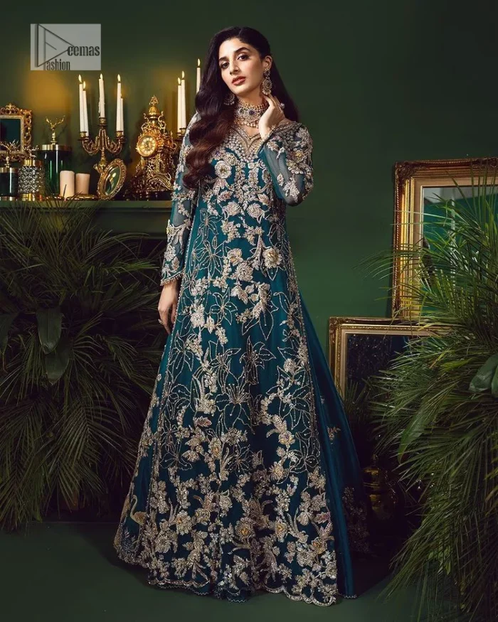 Let the outfit speak for itself! DeemasFashion presents this party wear in teal blue colour.  Be a centre of attraction by donning this beautiful teal blue long shirt embellished with tilla, dabka, kora, Kundan and sequins work which is further intensified with silver and golden embroidery. The shirt is emphasized with a sweetheart neckline and full sleeves to make your day super romantic. It is organized with a lehenga which is embellished with embroidered floral motifs to explain the love of the bride. To finish this article, the last but not least piece comes that is the dupatta which is adorned with four-sided heavily embellished borders and sequins spray that accentuates the whole look.