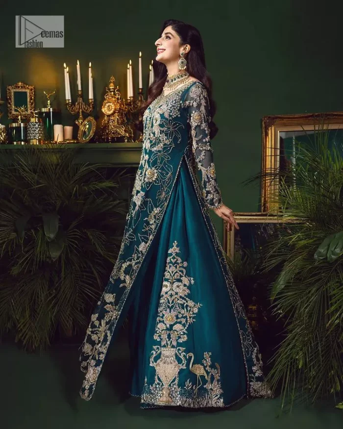 Let the outfit speak for itself! DeemasFashion presents this party wear in teal blue colour.  Be a centre of attraction by donning this beautiful teal blue long shirt embellished with tilla, dabka, kora, Kundan and sequins work which is further intensified with silver and golden embroidery. The shirt is emphasized with a sweetheart neckline and full sleeves to make your day super romantic. It is organized with a lehenga which is embellished with embroidered floral motifs to explain the love of the bride. To finish this article, the last but not least piece comes that is the dupatta which is adorned with four-sided heavily embellished borders and sequins spray that accentuates the whole look.