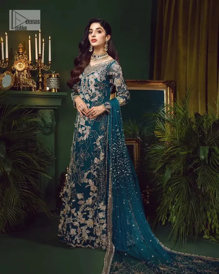 Let the outfit speak for itself! DeemasFashion presents this party wear in teal blue colour.  Be a centre of attraction by donning this beautiful teal blue long shirt embellished with tilla, dabka, kora, Kundan and sequins work which is further intensified with silver and golden embroidery. The shirt is emphasized with a sweetheart neckline and full sleeves to make your day super romantic. It is organized with a lehenga which is embellished with embroidered floral motifs to explain the love of the bride. To finish this article, the last but not least piece comes that is the dupatta which is adorned with four-sided heavily embellished borders and sequins spray that accentuates the whole look.