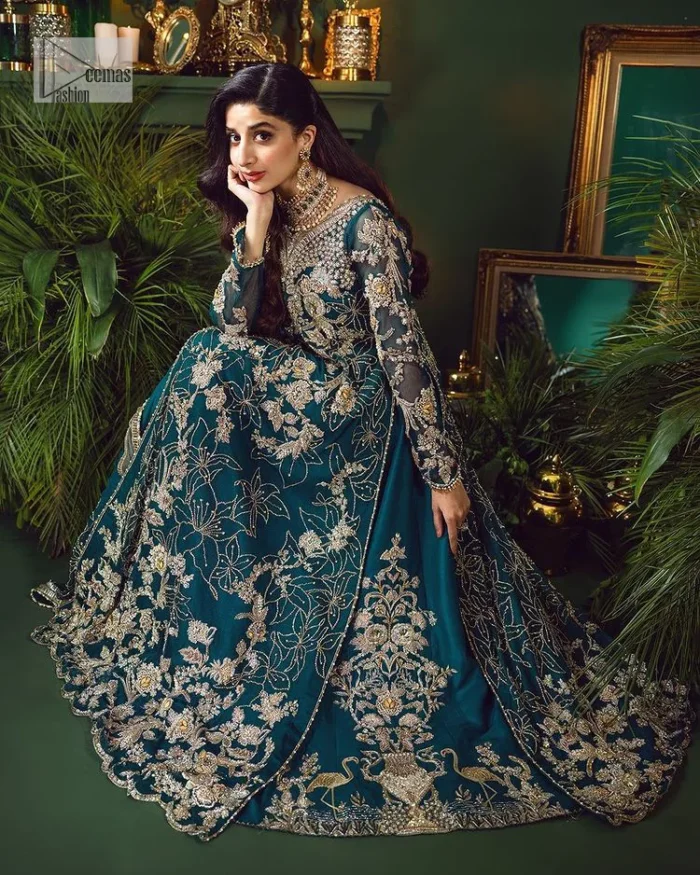 Let the outfit speak for itself! DeemasFashion presents this party wear in teal blue colour.  Be a centre of attraction by donning this beautiful teal blue long shirt embellished with tilla, dabka, kora, Kundan and sequins work which is further intensified with silver and golden embroidery. The shirt is emphasized with a sweetheart neckline and full sleeves to make your day super romantic. It is organized with a lehenga which is embellished with embroidered floral motifs to explain the love of the bride. To finish this article, the last but not least piece comes that is the dupatta which is adorned with four-sided heavily embellished borders and sequins spray that accentuates the whole look.