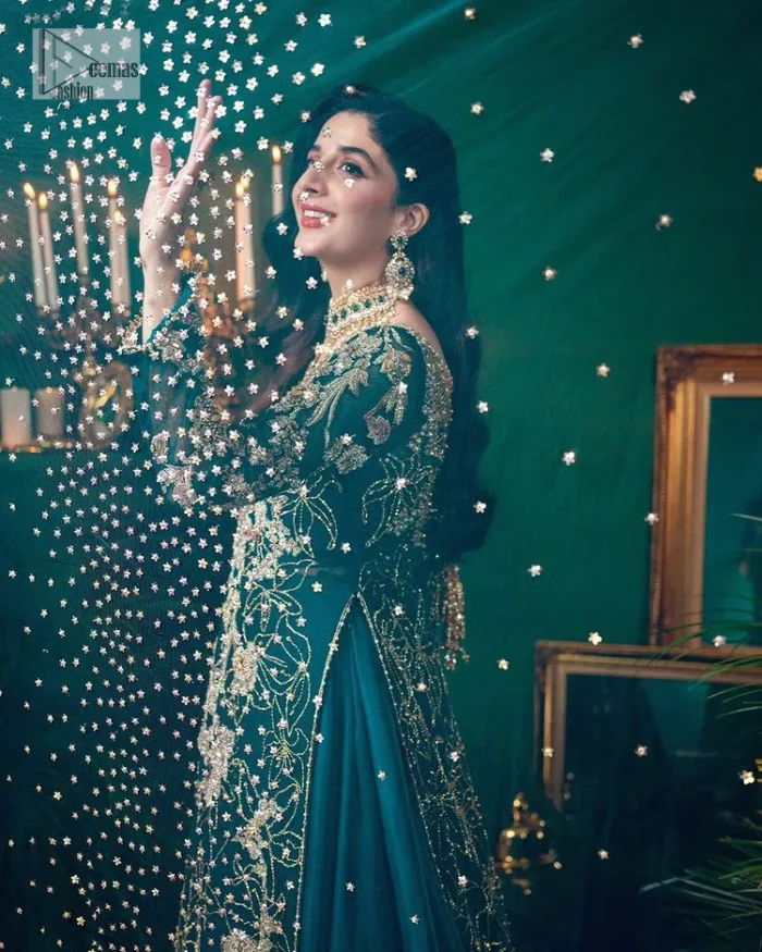 Let the outfit speak for itself! DeemasFashion presents this party wear in teal blue colour.  Be a centre of attraction by donning this beautiful teal blue long shirt embellished with tilla, dabka, kora, Kundan and sequins work which is further intensified with silver and golden embroidery. The shirt is emphasized with a sweetheart neckline and full sleeves to make your day super romantic. It is organized with a lehenga which is embellished with embroidered floral motifs to explain the love of the bride. To finish this article, the last but not least piece comes that is the dupatta which is adorned with four-sided heavily embellished borders and sequins spray that accentuates the whole look.