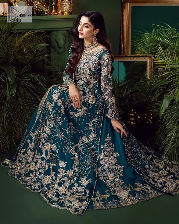 Let the outfit speak for itself! DeemasFashion presents this party wear in teal blue colour.  Be a centre of attraction by donning this beautiful teal blue long shirt embellished with tilla, dabka, kora, Kundan and sequins work which is further intensified with silver and golden embroidery. The shirt is emphasized with a sweetheart neckline and full sleeves to make your day super romantic. It is organized with a lehenga which is embellished with embroidered floral motifs to explain the love of the bride. To finish this article, the last but not least piece comes that is the dupatta which is adorned with four-sided heavily embellished borders and sequins spray that accentuates the whole look.