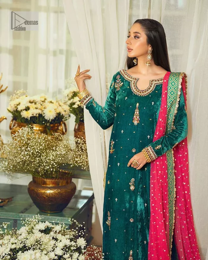 Brighten up your day with this beautiful ensemble. This long shirt style in a teal green colour is a perfect outfit that gives you a royal look on the festive occasion. The embroidered neckline and full sleeves make this outfit an epitome of beauty. Further, Embroidery work which enhances with tilla, dabka, kora, Kundan and lavish designs makes this outfit your priority for the day. It is paired with plum trousers which have finished edges to balance the overall look of the day. Complete this party wear with a dupatta in pink colour sparkling sequins spray all over. 