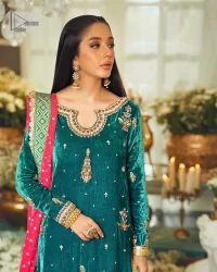 Brighten up your day with this beautiful ensemble. This long shirt style in a teal green colour is a perfect outfit that gives you a royal look on the festive occasion. The embroidered neckline and full sleeves make this outfit an epitome of beauty. Further, Embroidery work which enhances with tilla, dabka, kora, Kundan and lavish designs makes this outfit your priority for the day. It is paired with plum trousers which have finished edges to balance the overall look of the day. Complete this party wear with a dupatta in pink colour sparkling sequins spray all over. 