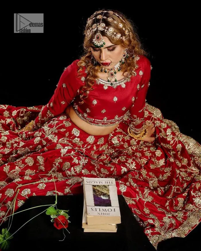 Reception called, and red answered. The stunning blouse is embellished with floral motifs. The base colour used for choli is wine red.  The sleeves of the blouse are embellished with floral patterns to make this reception wear the epitome of beauty. Further, the boat shape neckline also adds super charm and beauty when paired with a lehenga. The lehenga is adorned with golden embroidery which is further enhanced with tilla, dabka, kora, Kundan and the real magic of Zardozi. Complete this romantic article with a dupatta framed with a four-sided embellished border to give a glamorous touch to this magnificent attire.