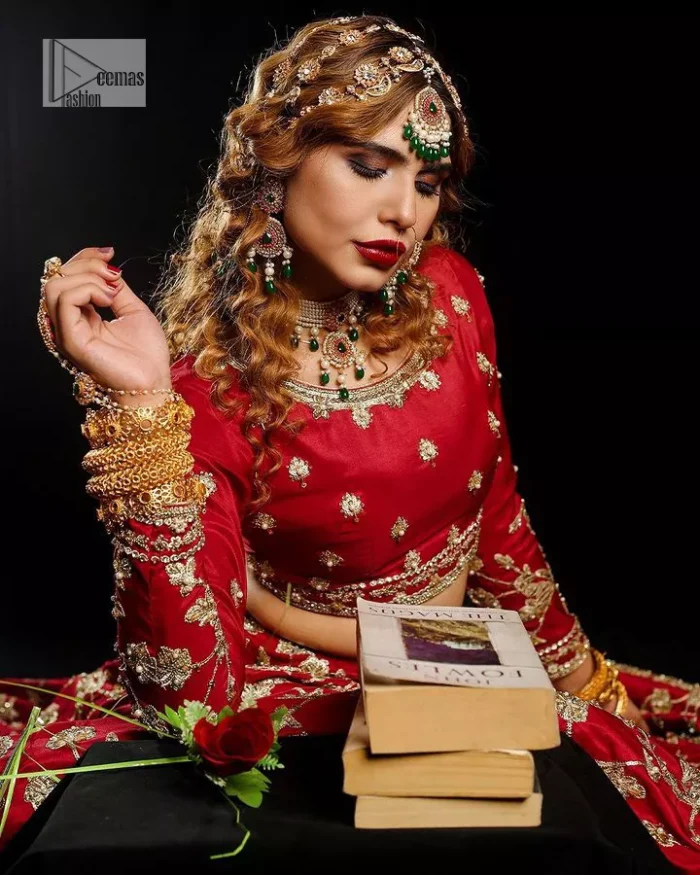 Reception called, and red answered. The stunning blouse is embellished with floral motifs. The base colour used for choli is wine red.  The sleeves of the blouse are embellished with floral patterns to make this reception wear the epitome of beauty. Further, the boat shape neckline also adds super charm and beauty when paired with a lehenga. The lehenga is adorned with golden embroidery which is further enhanced with tilla, dabka, kora, Kundan and the real magic of Zardozi. Complete this romantic article with a dupatta framed with a four-sided embellished border to give a glamorous touch to this magnificent attire.