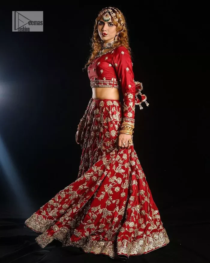 Reception called, and red answered. The stunning blouse is embellished with floral motifs. The base colour used for choli is wine red.  The sleeves of the blouse are embellished with floral patterns to make this reception wear the epitome of beauty. Further, the boat shape neckline also adds super charm and beauty when paired with a lehenga. The lehenga is adorned with golden embroidery which is further enhanced with tilla, dabka, kora, Kundan and the real magic of Zardozi. Complete this romantic article with a dupatta framed with a four-sided embellished border to give a glamorous touch to this magnificent attire.