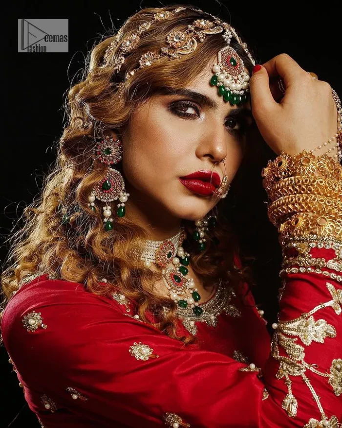 Reception called, and red answered. The stunning blouse is embellished with floral motifs. The base colour used for choli is wine red.  The sleeves of the blouse are embellished with floral patterns to make this reception wear the epitome of beauty. Further, the boat shape neckline also adds super charm and beauty when paired with a lehenga. The lehenga is adorned with golden embroidery which is further enhanced with tilla, dabka, kora, Kundan and the real magic of Zardozi. Complete this romantic article with a dupatta framed with a four-sided embellished border to give a glamorous touch to this magnificent attire.