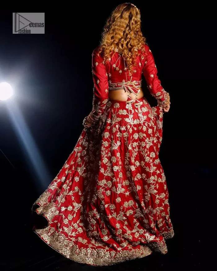 Reception called, and red answered. The stunning blouse is embellished with floral motifs. The base colour used for choli is wine red.  The sleeves of the blouse are embellished with floral patterns to make this reception wear the epitome of beauty. Further, the boat shape neckline also adds super charm and beauty when paired with a lehenga. The lehenga is adorned with golden embroidery which is further enhanced with tilla, dabka, kora, Kundan and the real magic of Zardozi. Complete this romantic article with a dupatta framed with a four-sided embellished border to give a glamorous touch to this magnificent attire.