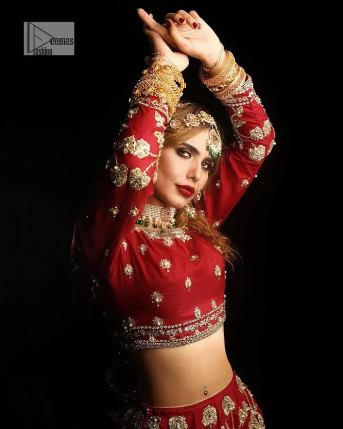 Reception called, and red answered. The stunning blouse is embellished with floral motifs. The base colour used for choli is wine red.  The sleeves of the blouse are embellished with floral patterns to make this reception wear the epitome of beauty. Further, the boat shape neckline also adds super charm and beauty when paired with a lehenga. The lehenga is adorned with golden embroidery which is further enhanced with tilla, dabka, kora, Kundan and the real magic of Zardozi. Complete this romantic article with a dupatta framed with a four-sided embellished border to give a glamorous touch to this magnificent attire.