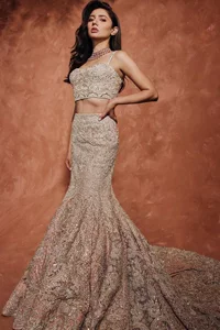 Chill vibes on your big day with this walima outfit. A soft pink blouse is embellished in tilla,dabka, kora, Kundan and crystals with a fish cut style lehenga with a huge trail at the back. The blouse has a sweetheart neckline to make this outfit romantic. Further, the blouse is embellished with silver embroidery just to make you a spotlight of the show. The sleeveless style makes this masterpiece unique and lovely. It is paired up with a fish-cut lehenga in the same colour. The heavy bak train lehenga is adorned with embroidery making a bride look more regal than a costume.